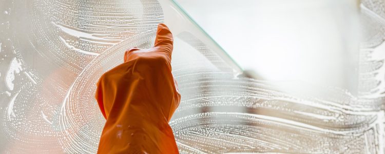 close-up-hand-with-rubber-glove-cleaning-window